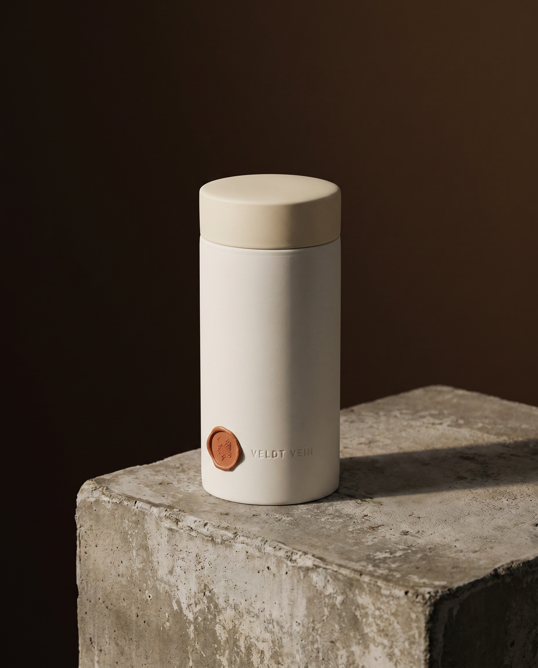 The Karoo Capsule on a concrete plinth — debossed VELDT & VEIN wordmark, terracotta wax seal.