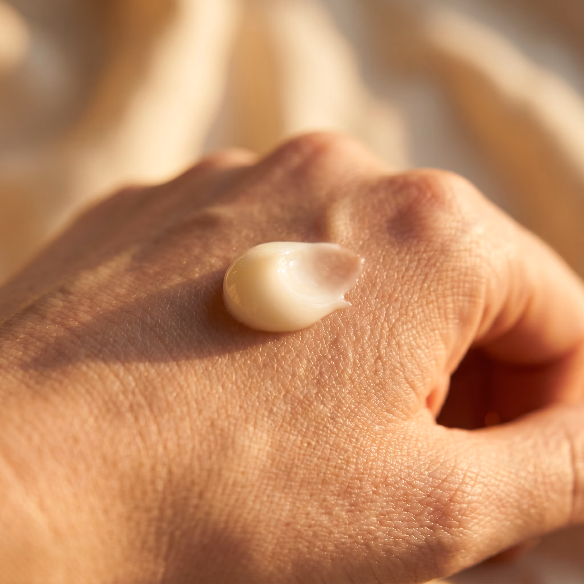 A pearl of hand cream on the back of a hand, just before being smoothed in.