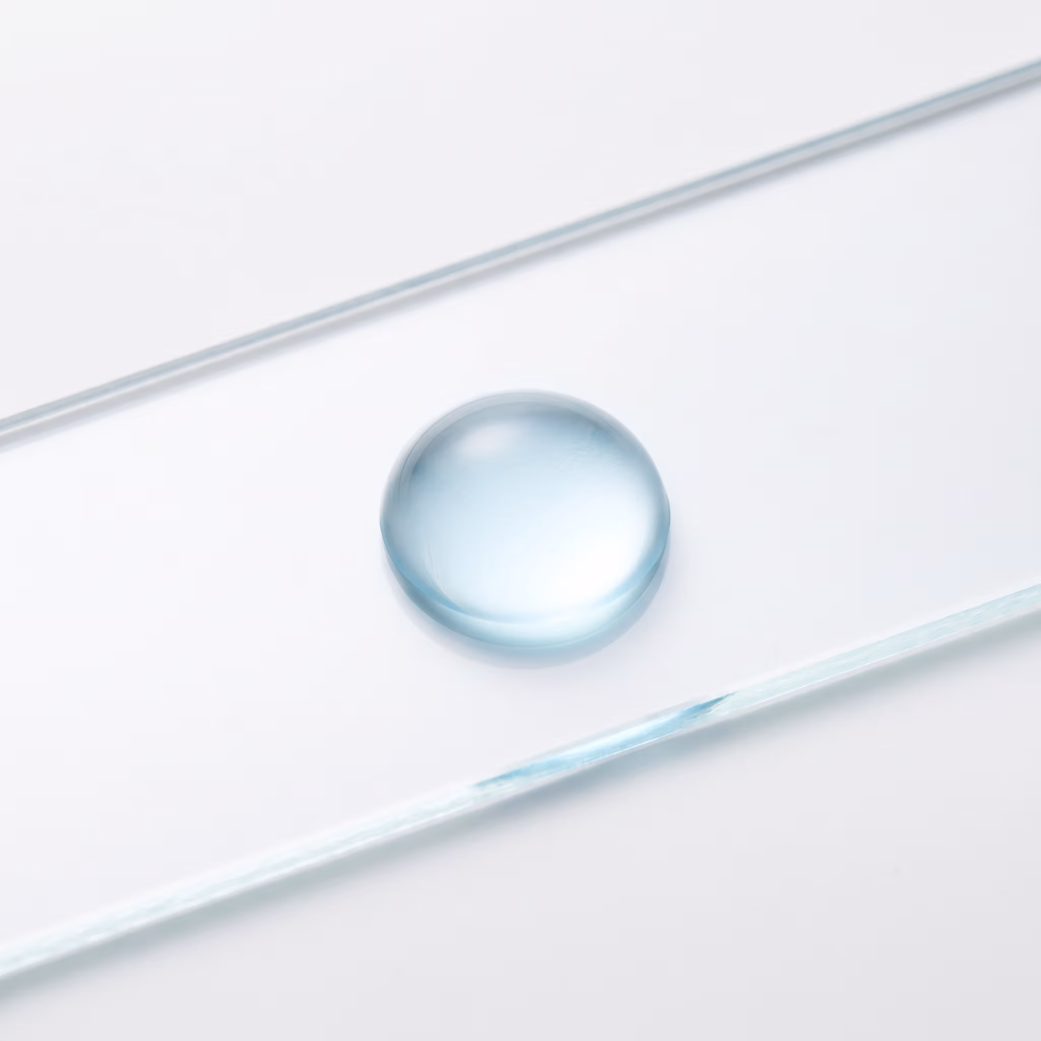A copper peptide solution — a single blue drop on glass, lit from below.